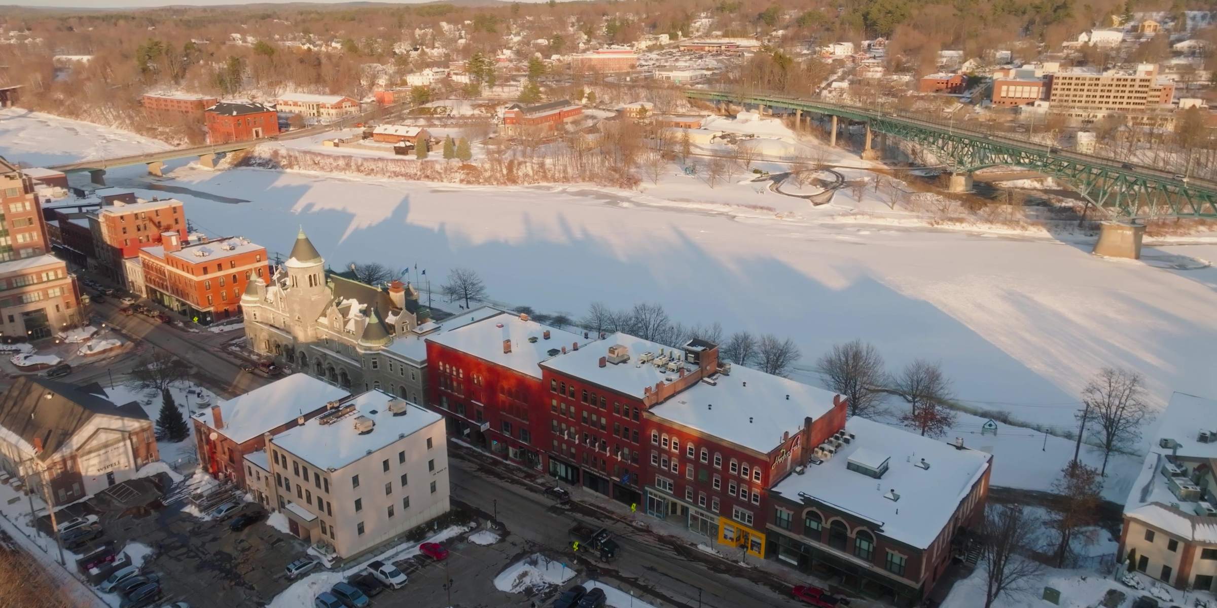 Aerial view of downtown Augusta, Maine, with snow on the rooftops and ice on the Kennebec River